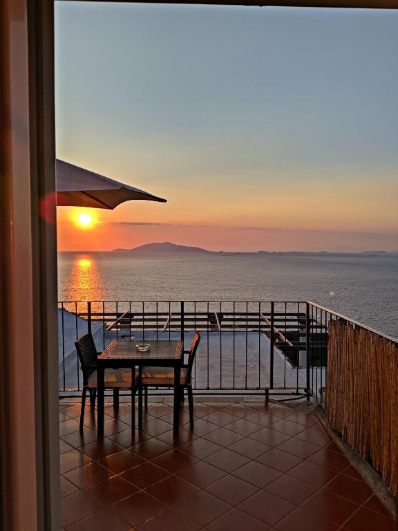 a table and chairs on a balcony with a sunset at B&B Il Paradiso di Capri in Anacapri