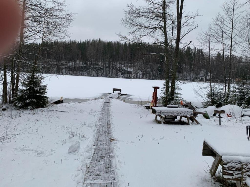 pokryte śniegiem pole ze stołami piknikowymi i ławkami w obiekcie Kuhasensaari Lomakeskus w mieście Lemi