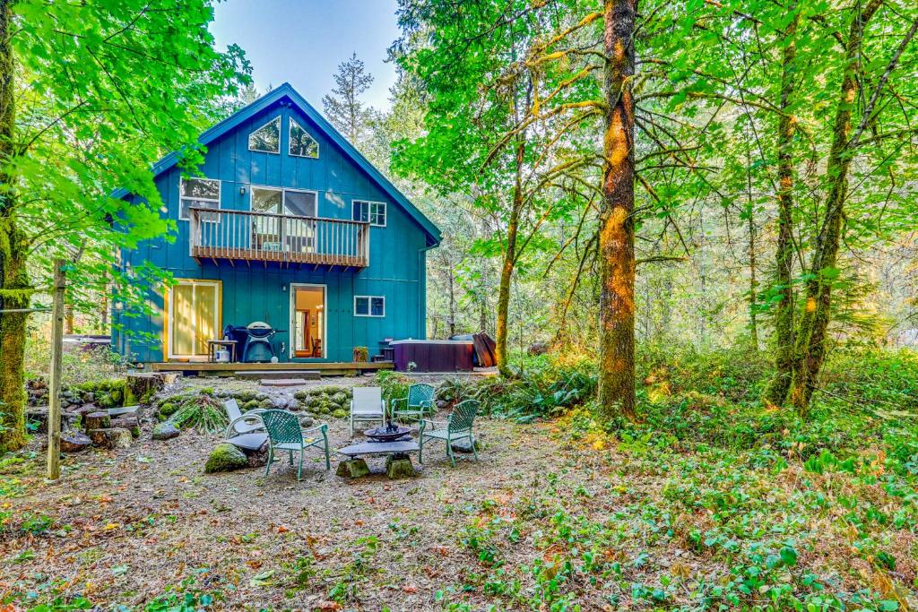 ein blaues Haus mitten im Wald in der Unterkunft Wildwood Cabin in Welches