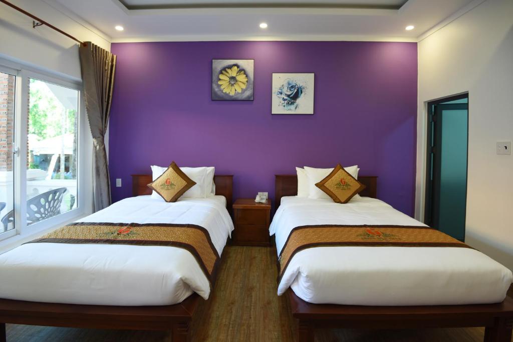 2 Betten in einem Zimmer mit lila Wänden in der Unterkunft Đồi Sao Phú Quốc in Phu Quoc