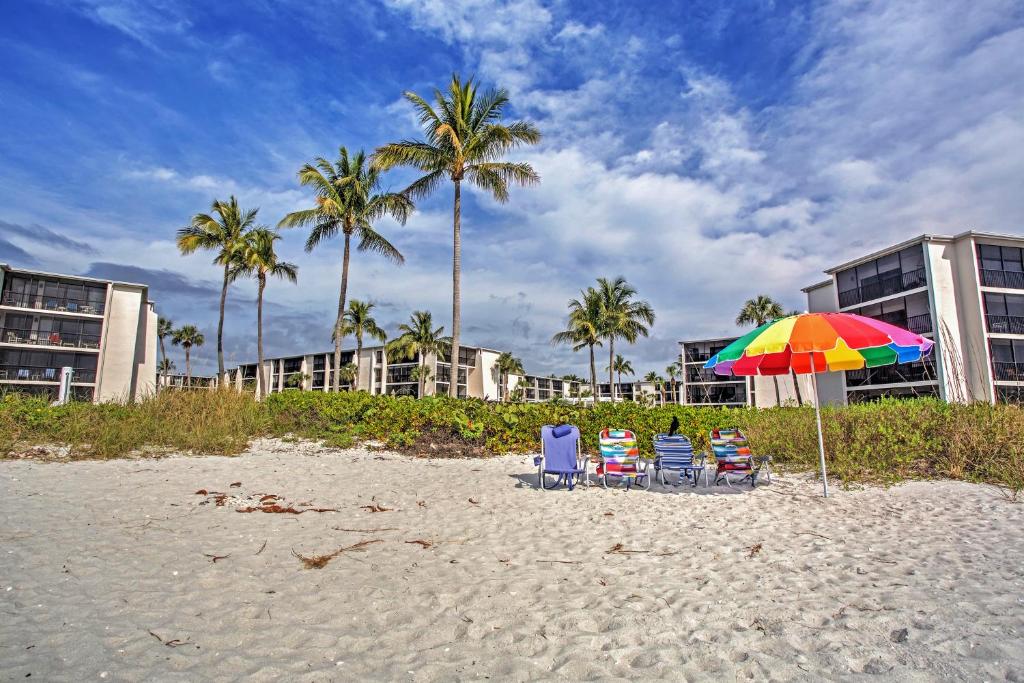 薩尼貝爾的住宿－Sanibel Island Studio with Pool Access Walk to Beach，海滩上的两把椅子和一把遮阳伞