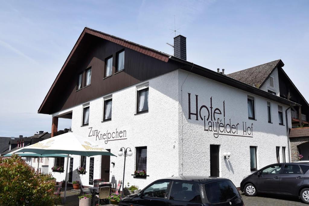 een groot wit gebouw met tekst aan de zijkant bij Hotel Laufelder Hof in Laufeld
