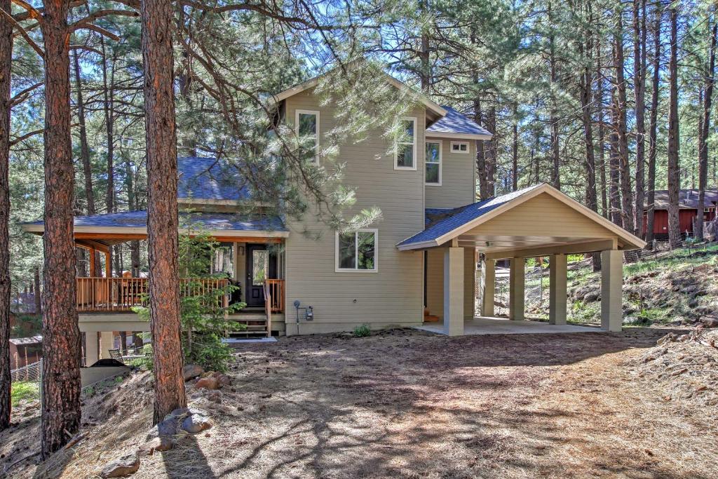 a house with a porch in the woods at Flagstaff Family Retreat with Patio and Mountain Views in Mountainaire