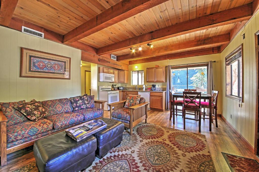 a living room with a couch and a table and a kitchen at Big Bear Cabin with Fenced Yard 4 Mi to Snow Summit in Big Bear City