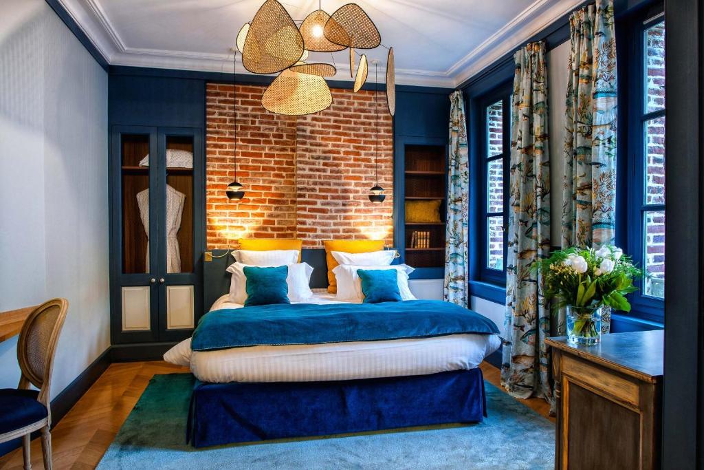 翁弗勒爾的住宿－拉皮提特佛利酒店，一间拥有蓝色墙壁的卧室和一张位于客房内的床