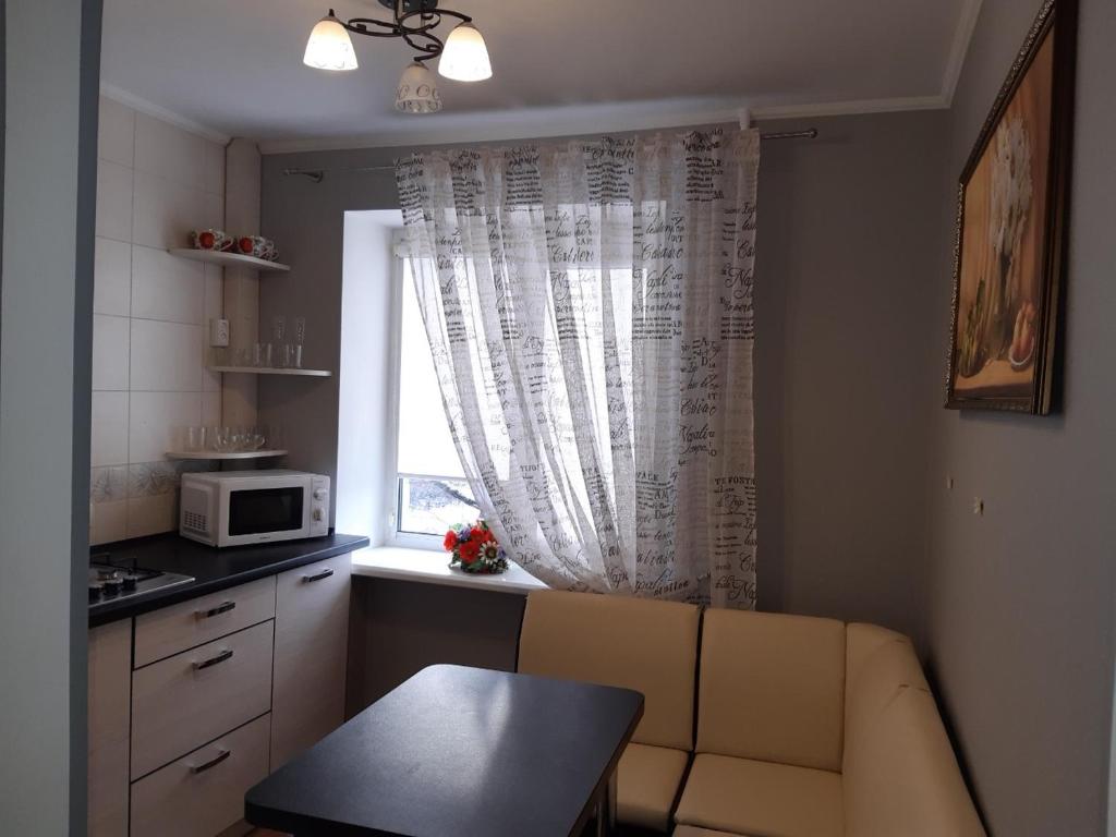 uma cozinha com um sofá em frente a uma janela em Аппартаменты на Бутырина em Kremenchuk