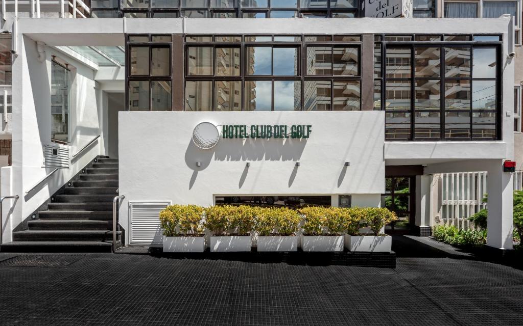 
a white building with a sign on the side of it at Hotel Club del Golf in Mar del Plata
