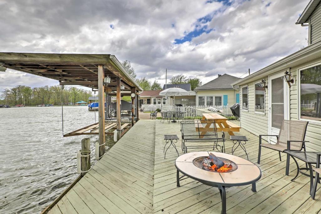 a wooden deck with a fire pit on the water at Waterfront Indian Lake House Deck and Private Dock! in Lakeview