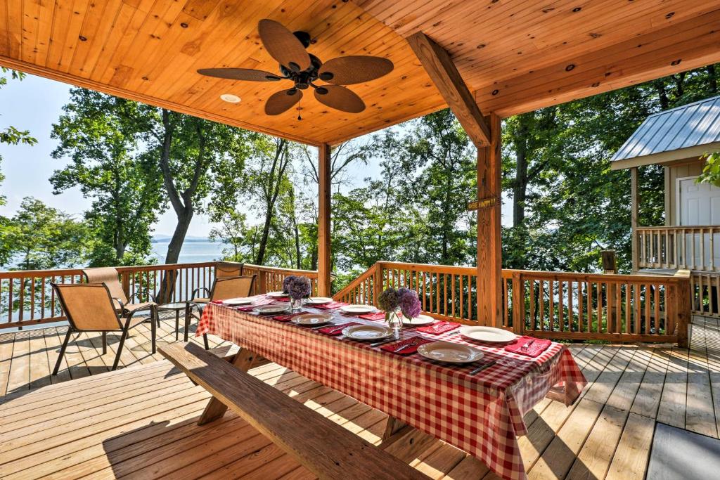 a wooden deck with a table and a ceiling fan at Lakefront Rutledge Home with Fire Pit and Private Dock in Rutledge