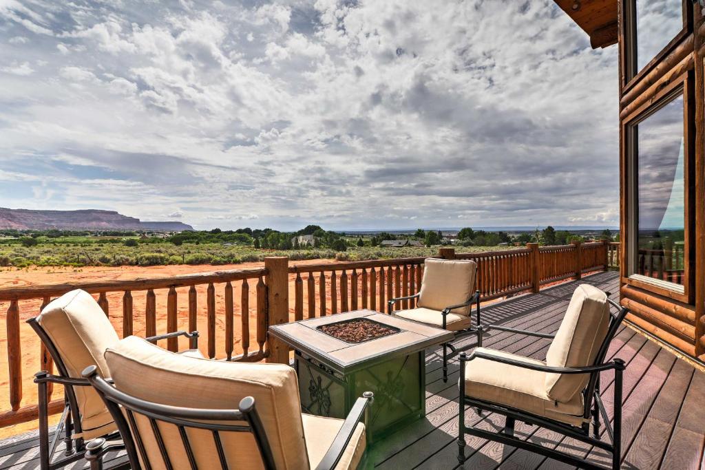 a porch with chairs and a table on a deck at Dreamy Kanab Cabin with Hot Tub and Panoramic Views! in Kanab