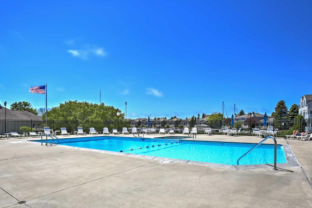 a large swimming pool with chairs and an american flag at Manistee Retreat with Pool Access, Walk to Beach! in Manistee