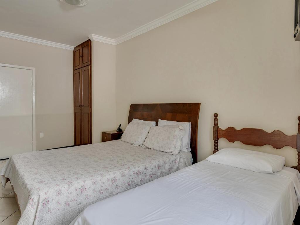 dos camas sentadas una al lado de la otra en un dormitorio en Hotel Estrela Do Vale, en Ipatinga