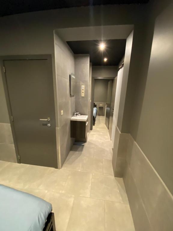 a hallway with a bathroom with a sink and a door at Appartement Studio Tournai in Tournai