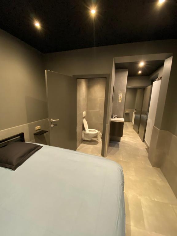 a bedroom with a bed and a bathroom with a toilet at Appartement Studio Tournai in Tournai