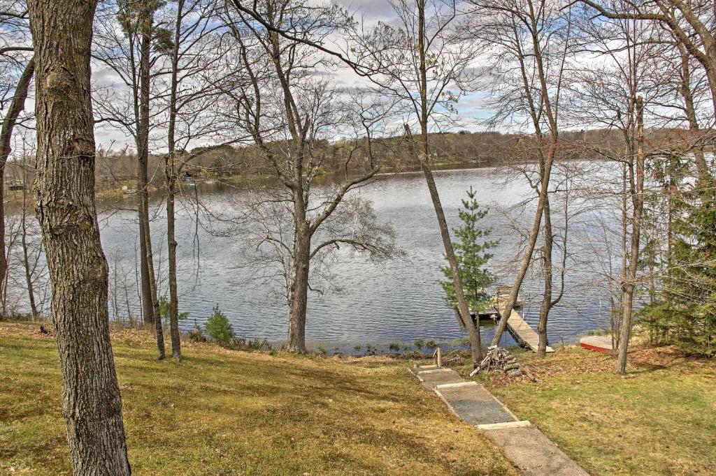 a view of a lake with a dock and trees at Cozy Balsam Lake Home Deck, Private Dock and Kayaks in Balsam Lake