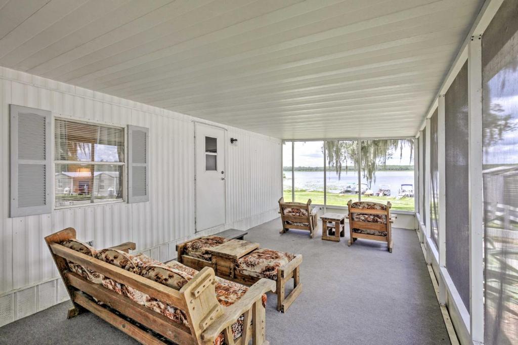 porche con bancos, mesa y ventanas en Lakeside Silver Springs Cabin with On-Site Boat Ramp, en Silver Springs