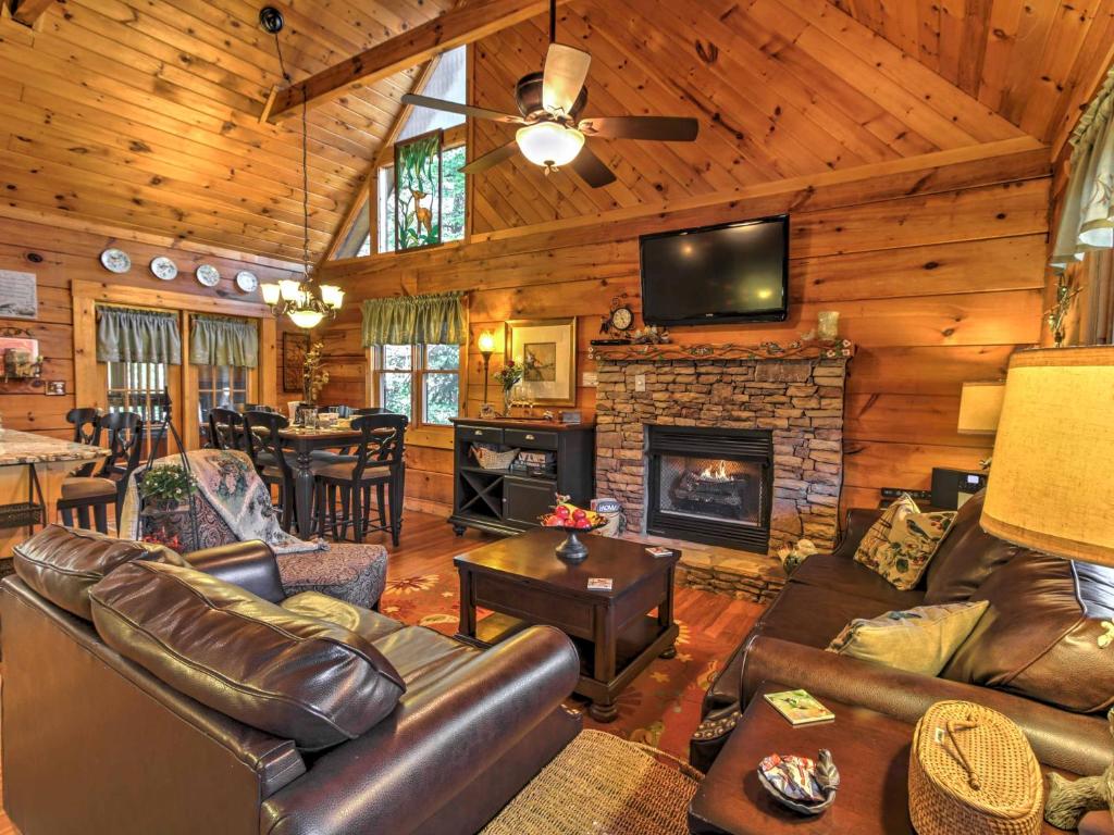 a living room with leather furniture and a fireplace at Cozy Nest Gatlinburg Cabin with Porch and Jacuzzi! in Gatlinburg