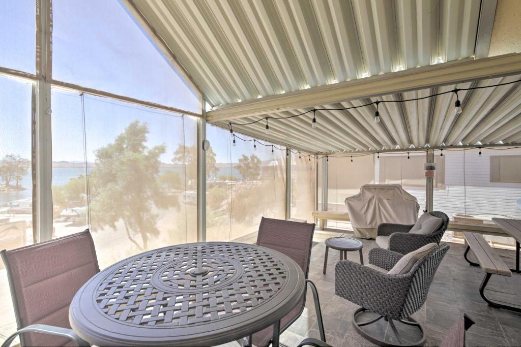 une table et des chaises dans une chambre avec une grande fenêtre dans l'établissement Lake Havasu Cabin with Lake and Mtn Views, Boat Launch, à Lake Havasu City