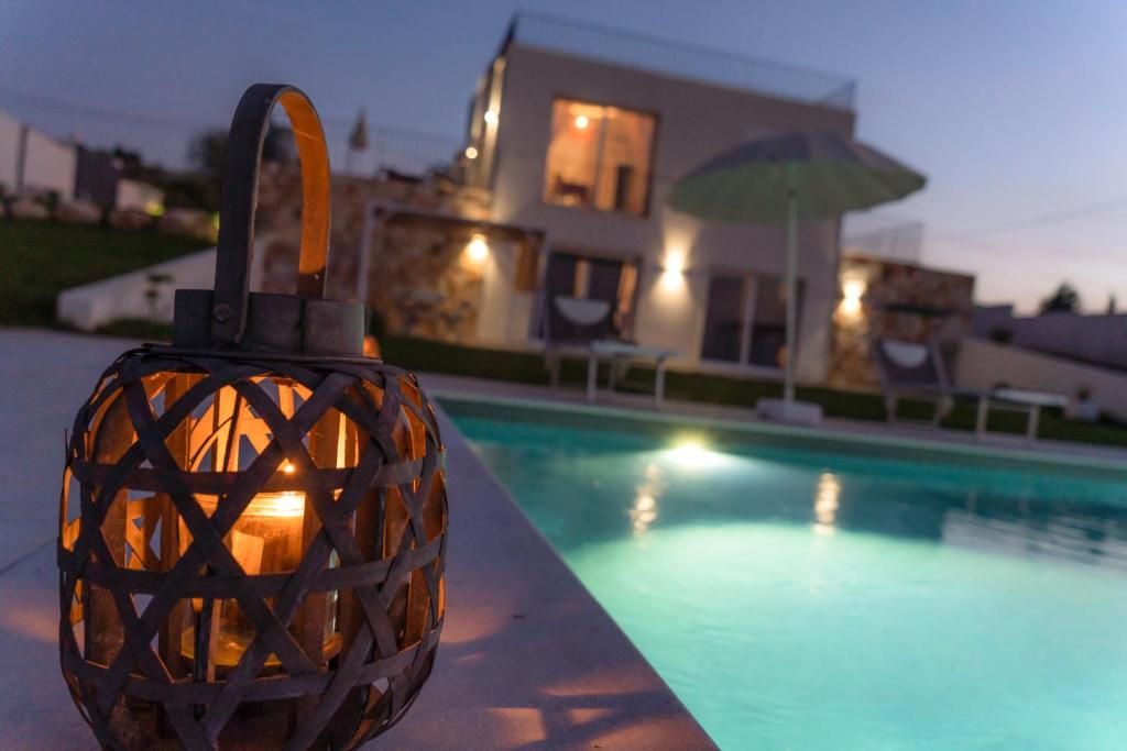 a lantern is sitting next to a swimming pool at Villa Triona Marzamemi con Piscina in Marzamemi