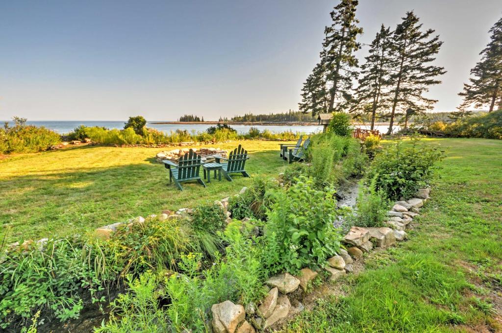 a garden with two benches and a table in the grass at Waterfront Prospect Harbor Cottage Yard, Fire Pit in Prospect Harbor
