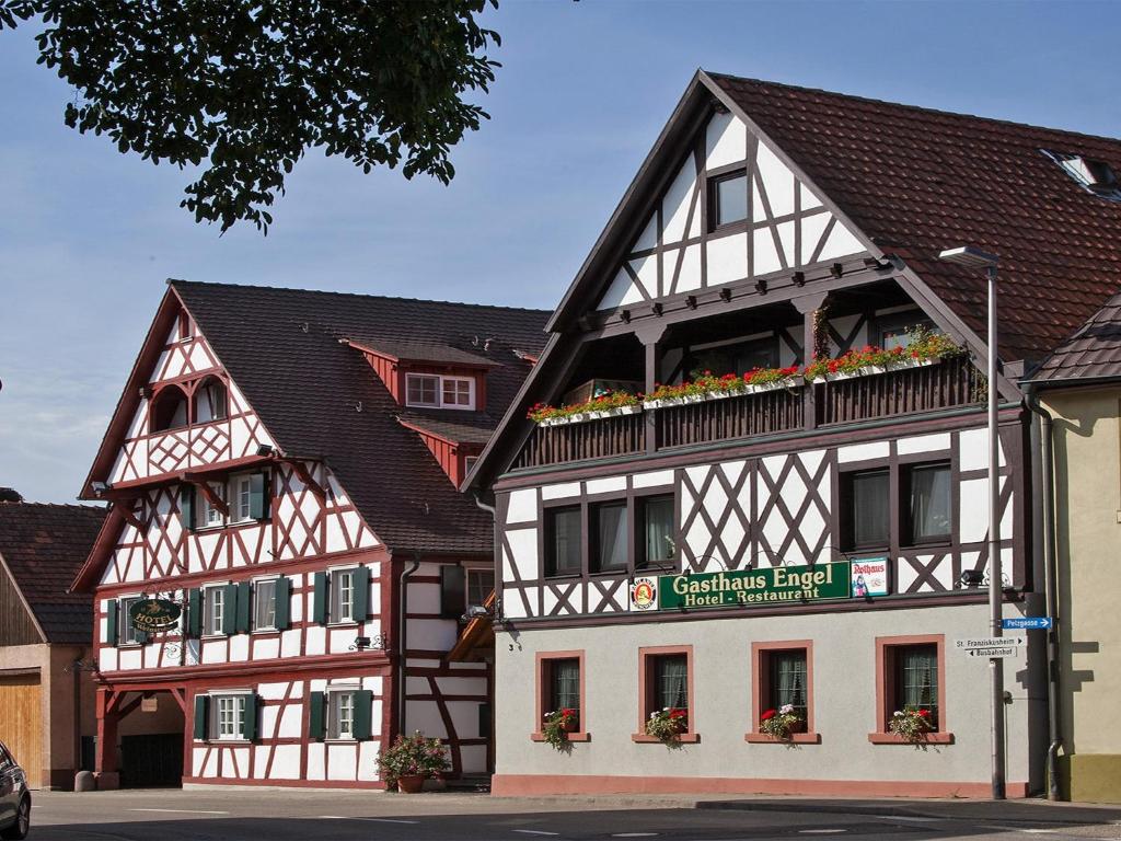 ein zweistöckiges Gebäude mit Blumen an den Fenstern in der Unterkunft Hotel Engel in Rheinmunster