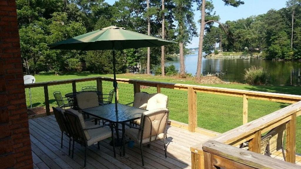 un tavolo e sedie su una terrazza con ombrellone di Rivers Edge Retreat with Kayaks and River Access! a Reedville
