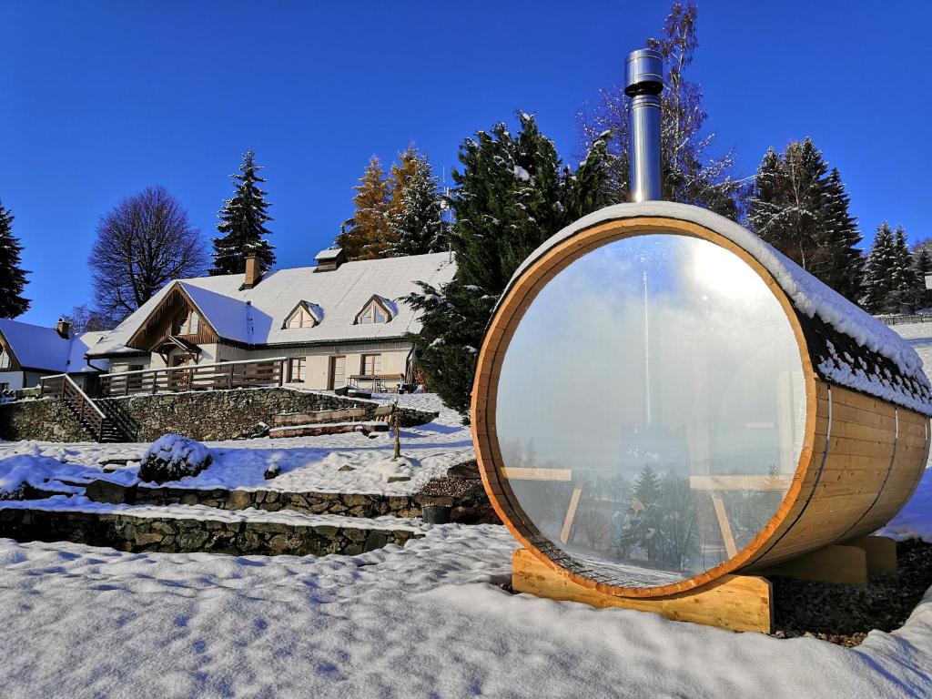 a round mirror in the snow in front of a house at Hotel Gabriela in Vítkovice