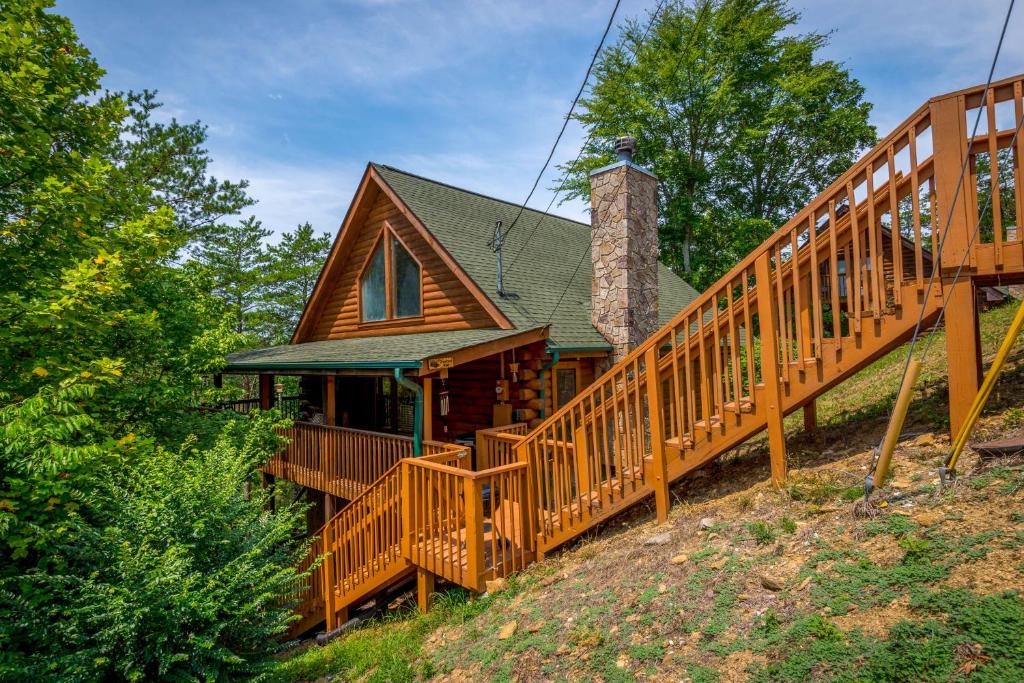 a home with a wooden staircase leading up to a house at Inviting Sevierville Cabin with Deck and Hot Tub! in Sevierville