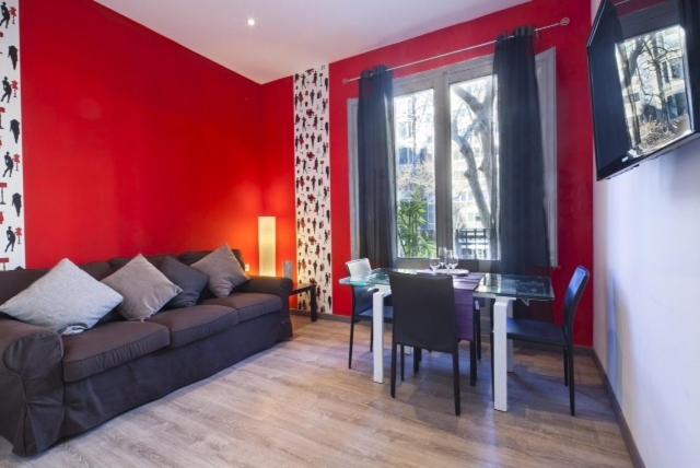 バルセロナにあるPaseo de Gracia Apartmentsの赤いリビングルーム(ソファ、テーブル付)