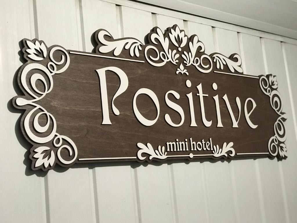 キーウにあるМини Отель «Positive”の建物の横に薔薇が書かれている看板