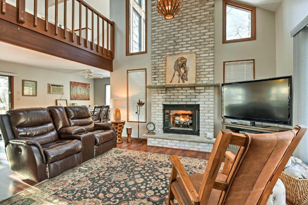 a living room with a couch and a fireplace at Poconos Vacation Rental with Pool Access and Hot Tub! in Bushkill