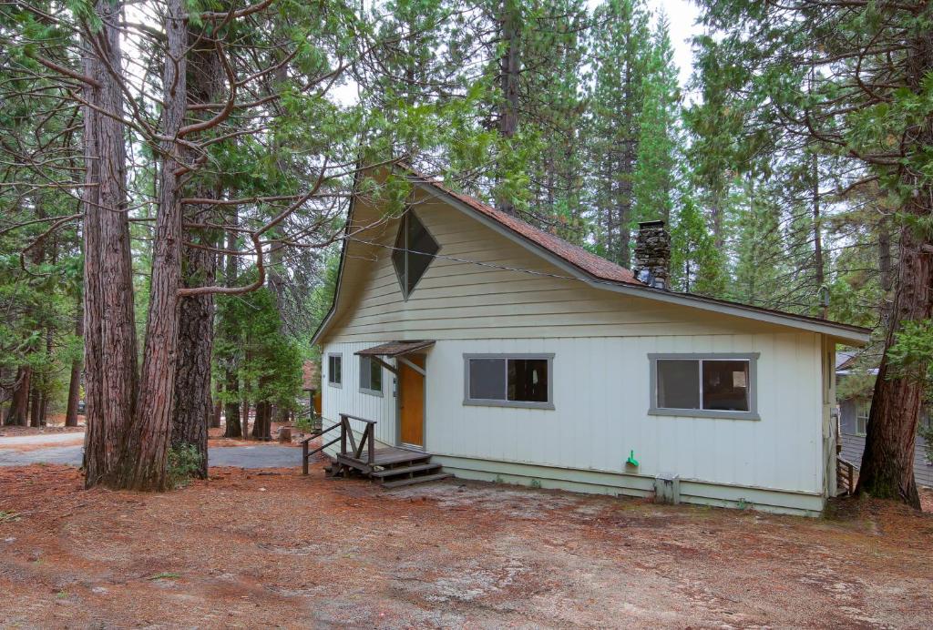 a small white house in the middle of a forest at 25A Villarreal Retreat in Wawona