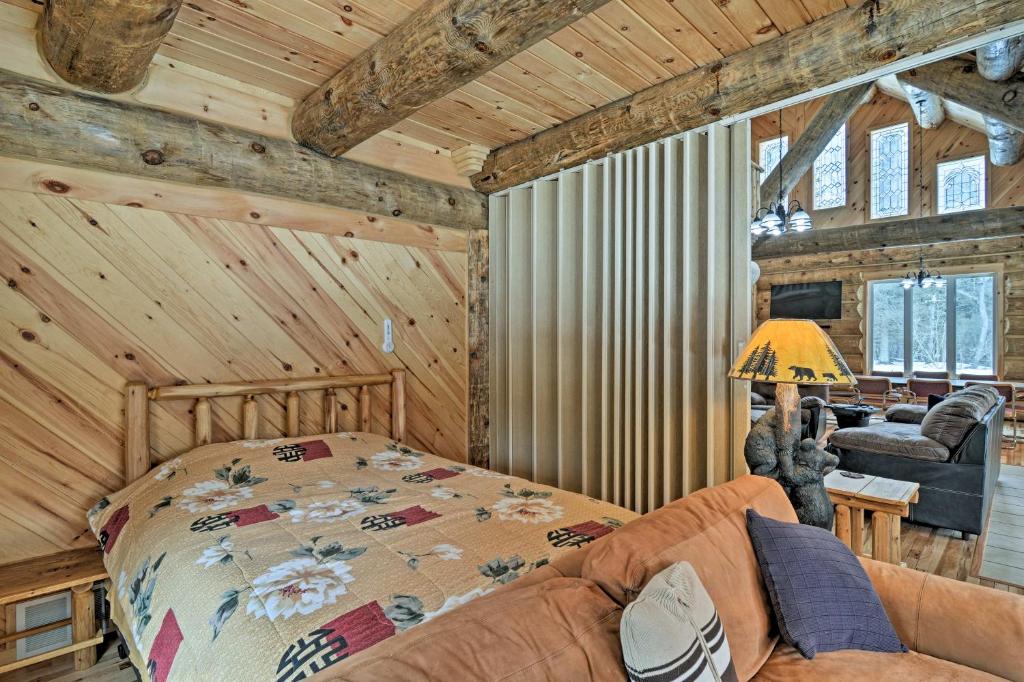 ein Schlafzimmer mit einem Bett und einem Sofa in einem Zimmer in der Unterkunft Custom Log Cabin with Deck and 45 Acres by Pine River! in Tustin