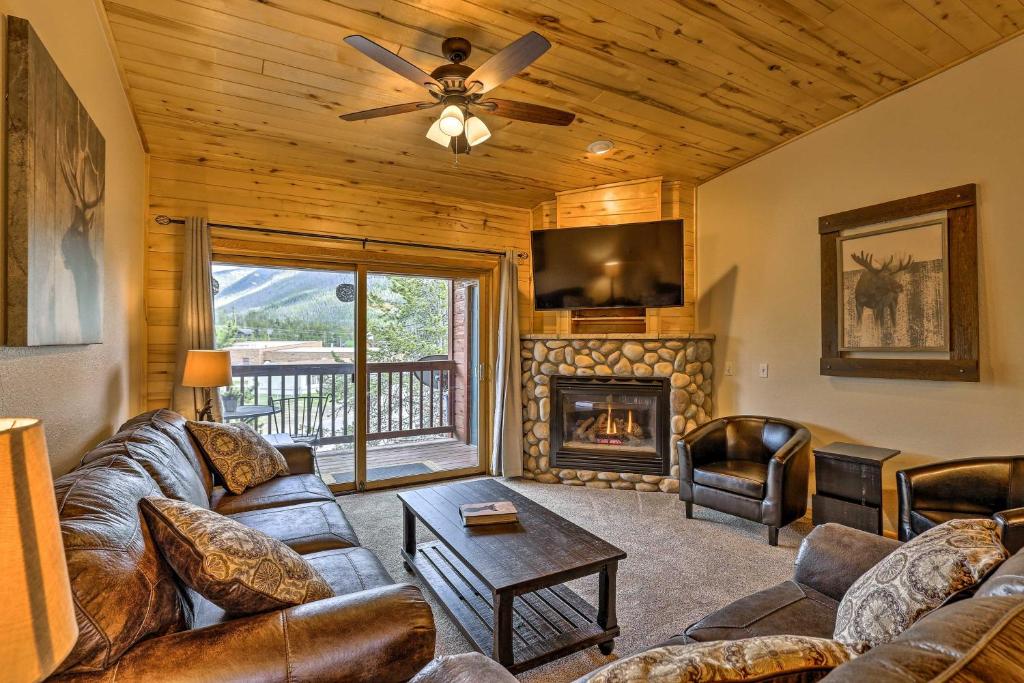 een woonkamer met een bank en een open haard bij Mountain-View Condo with Deck Walk to Grand Lake in Grand Lake