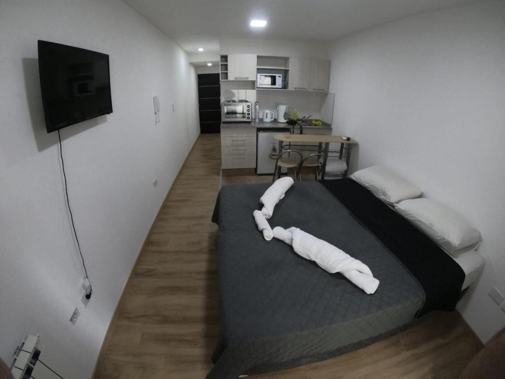 1 dormitorio con 1 cama grande con almohadas blancas en Departamento Aires Verdes de Salta en Salta