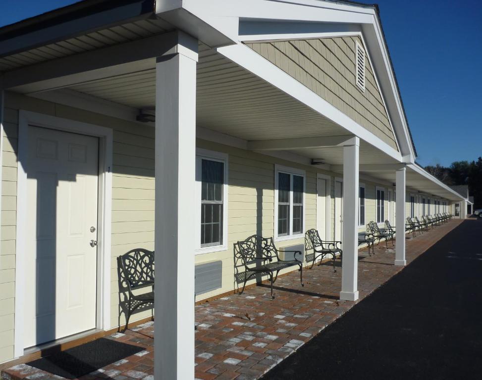 une rangée de bancs sur le côté d'un bâtiment dans l'établissement Yankee Clipper Motel, à Belfast