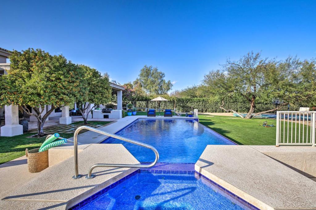 a swimming pool in a yard next to a house at Lavish Paradise Valley Home with Sports Court and Pool in Scottsdale