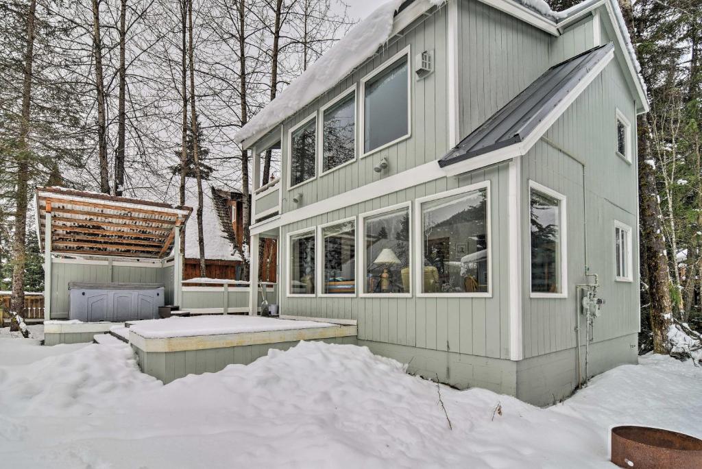 a house in the snow in the woods at Cabin with Hot Tub and Views 1 Mile to Alyeska Resort in Girdwood