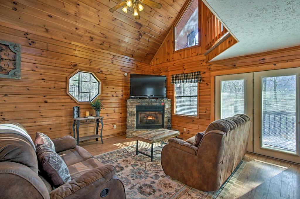 a living room with a fireplace and a tv at Sevierville Cabin with Hot Tub, Views and Pool Access! in Sevierville