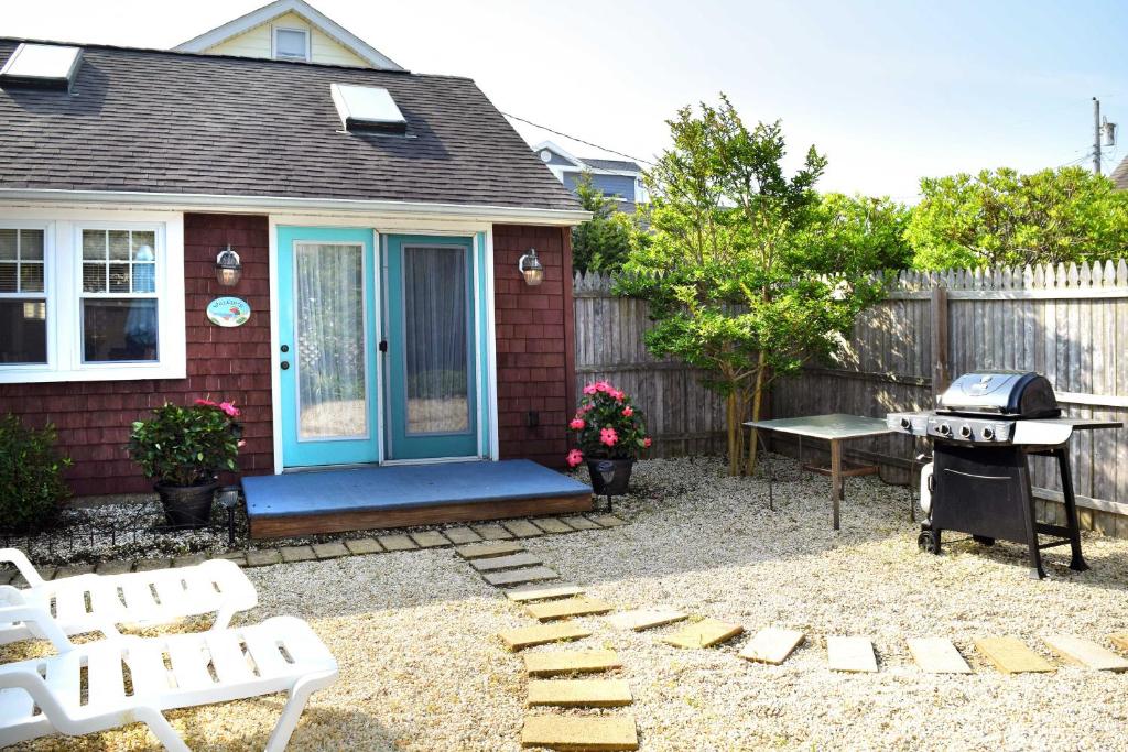 a small house with a blue door and a grill at Charming Surf City Cottage - Steps to Beach and Bay! in Surf City