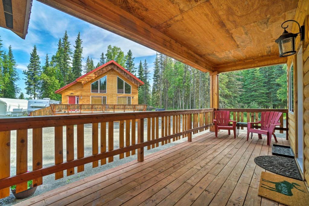 a large deck with two chairs and a log cabin at Soldotna Fishing Cabin about Half-Mi to Kenai River! in Soldotna