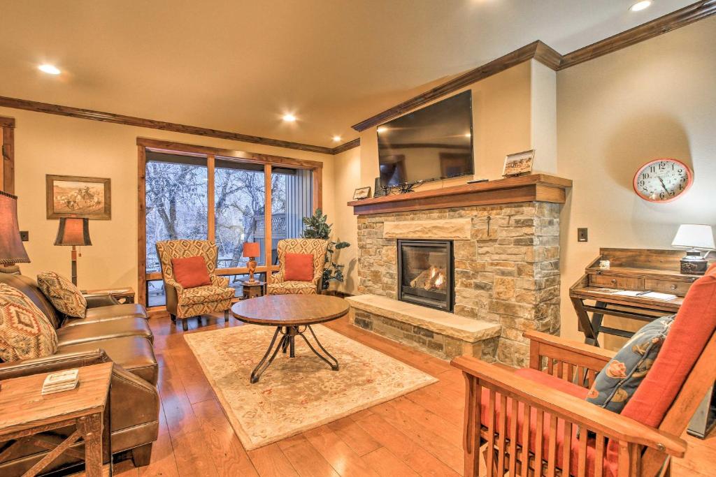 a living room with a fireplace and a piano at Red Lodge Townhome with Private Hot Tub and Mtn Views! in Red Lodge
