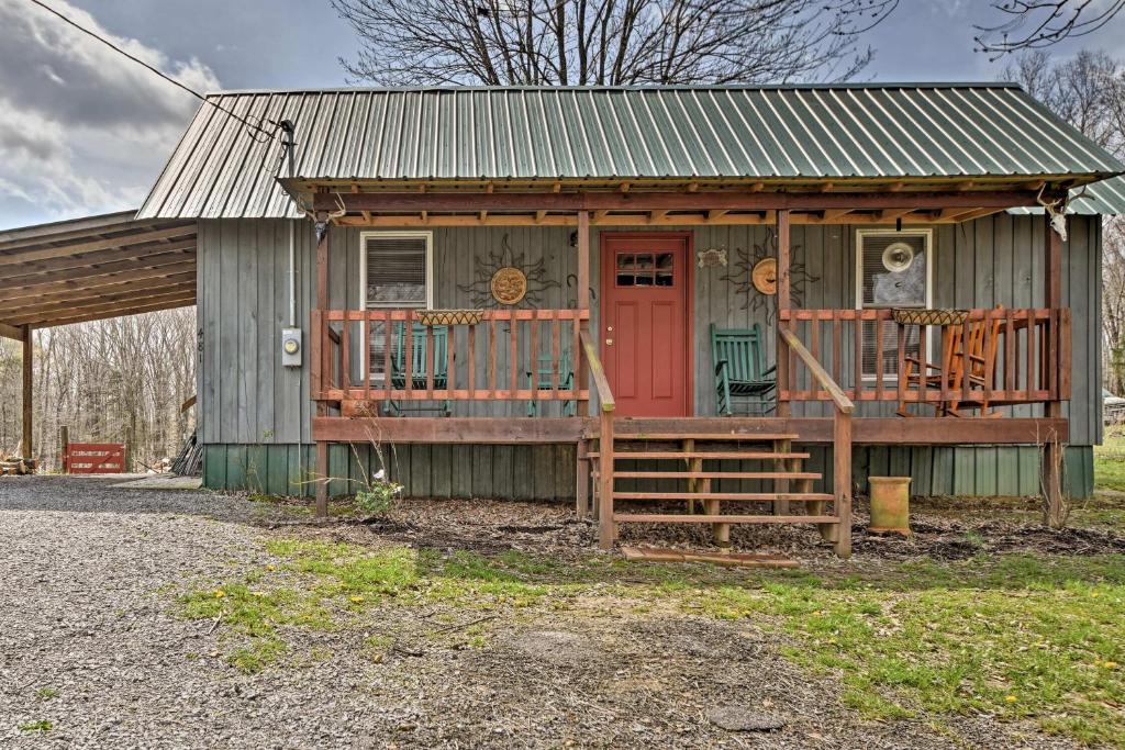 a small house with a red door and a porch at Remote Kentucky Cabin with Fire Pit and 2 Ponds in New Concord