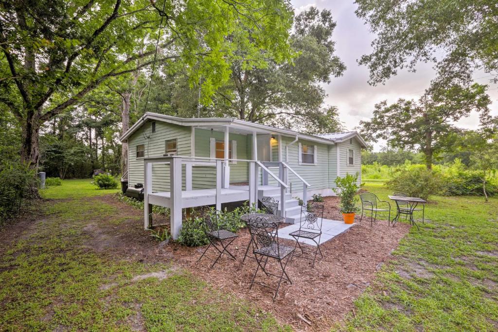 a tiny house with a porch and tables and chairs at Cozy OBrien Home with Fire Pit and Patio Near Rivers! in Branford