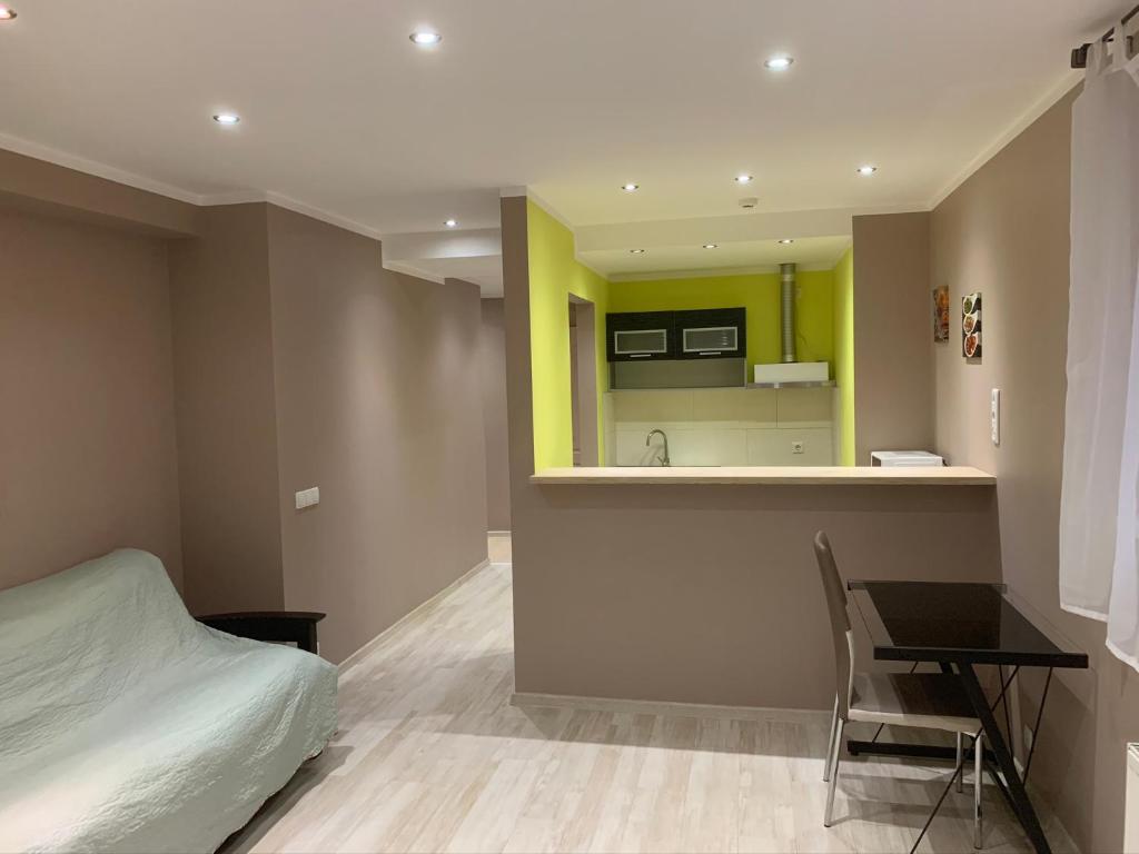 ein Schlafzimmer mit einem Bett und einem Schreibtisch sowie eine Küche in der Unterkunft Riverside Promenade apartment M in Riga