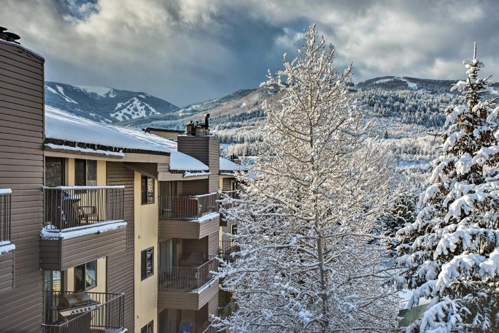 a snow covered tree in front of some buildings at Colorado Escape with Pool Access and Mountain Views! in Avon