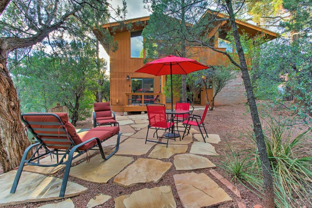a patio with chairs and an umbrella in front of a house at Romantic Sedona Suite with Patio Less Than 1 Mi to Trails in Sedona