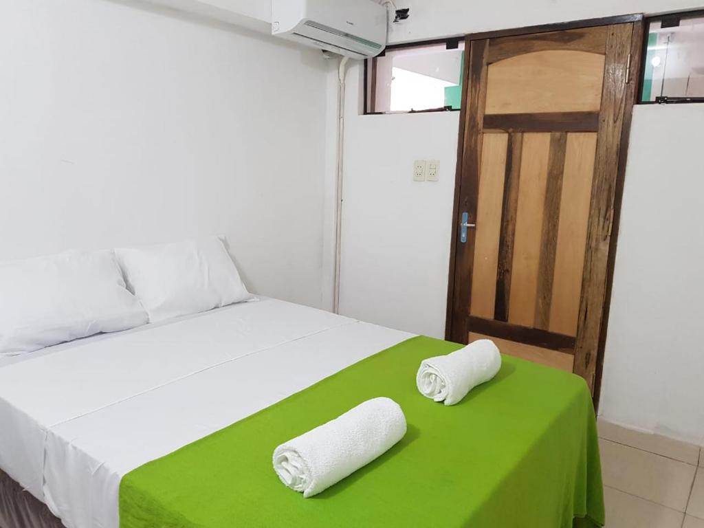 a bedroom with a bed with two towels on it at Helecho's Hostal in Encarnación