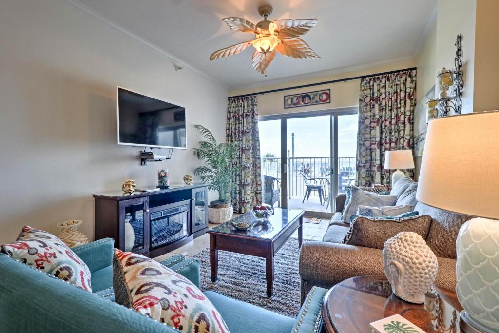 a living room with a couch and a fireplace and a tv at Beachfront Condo with Pool Access in Biloxi! in Biloxi