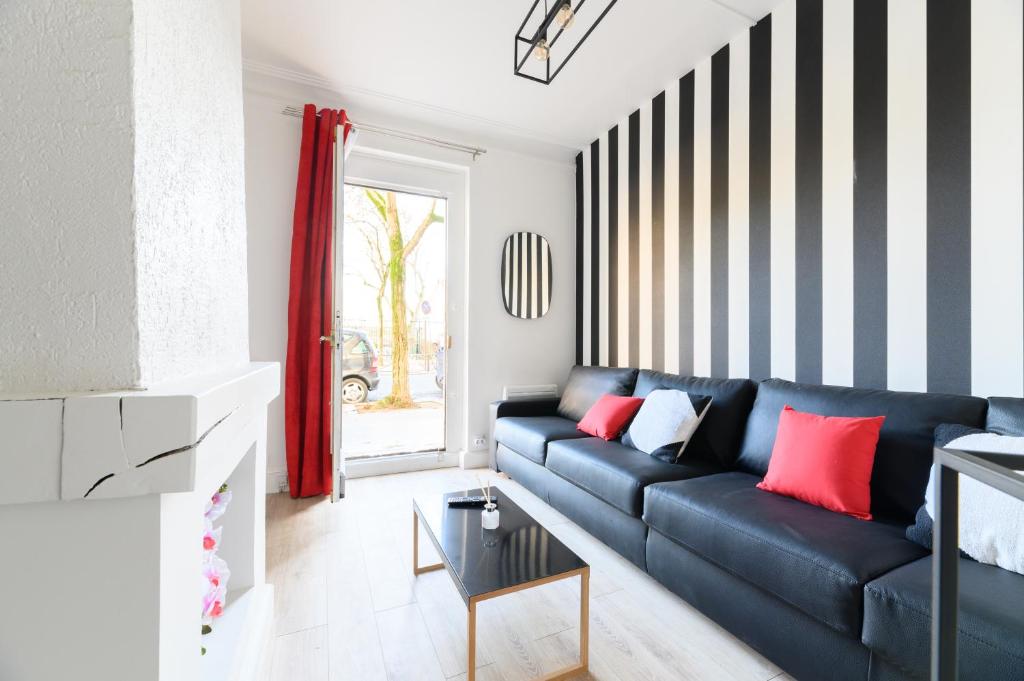 a living room with a blue couch with red pillows at Daumier - New 2 Bdrs Flat near la Seine in Paris